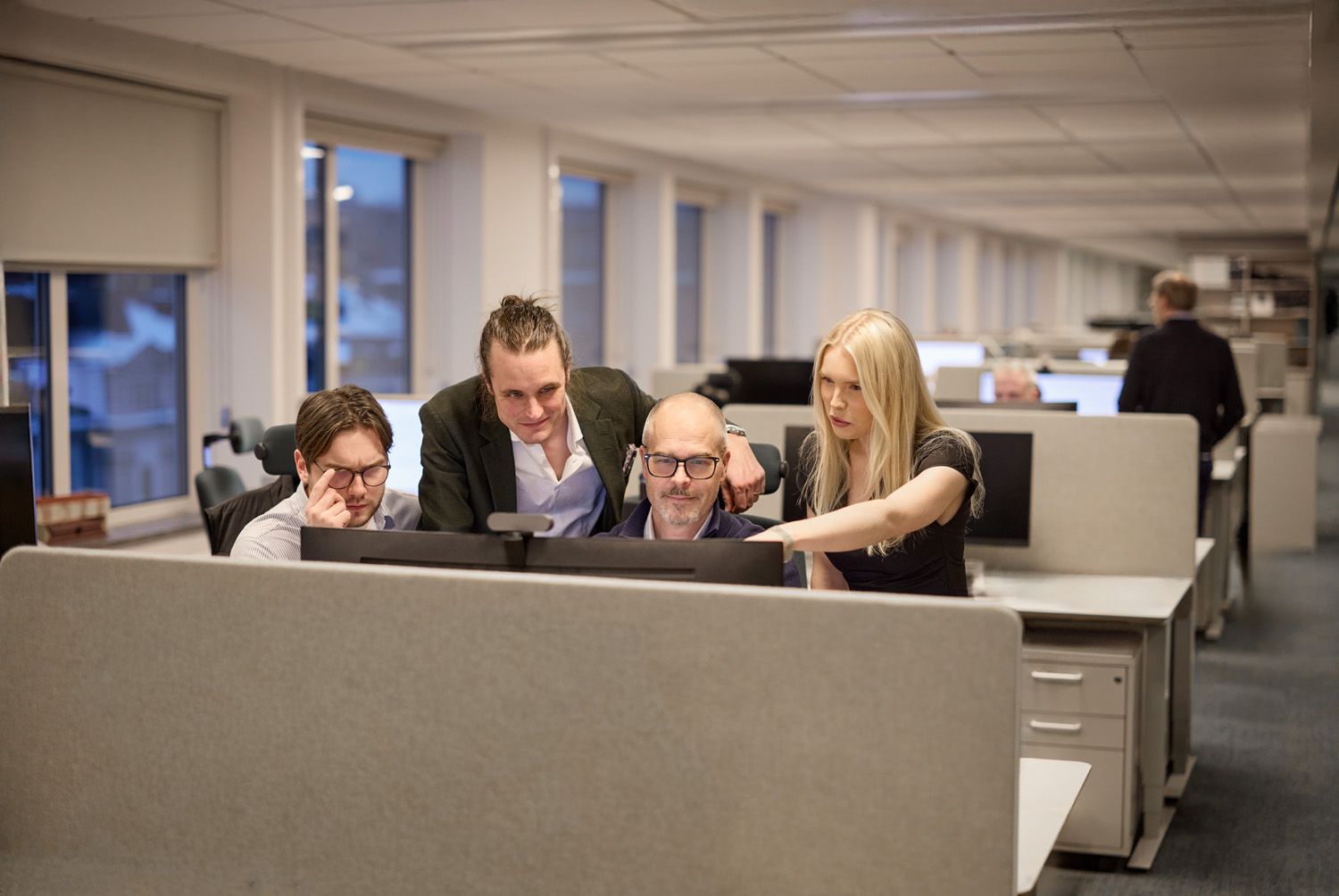 Män och kvinnor diskuterar framför skärm