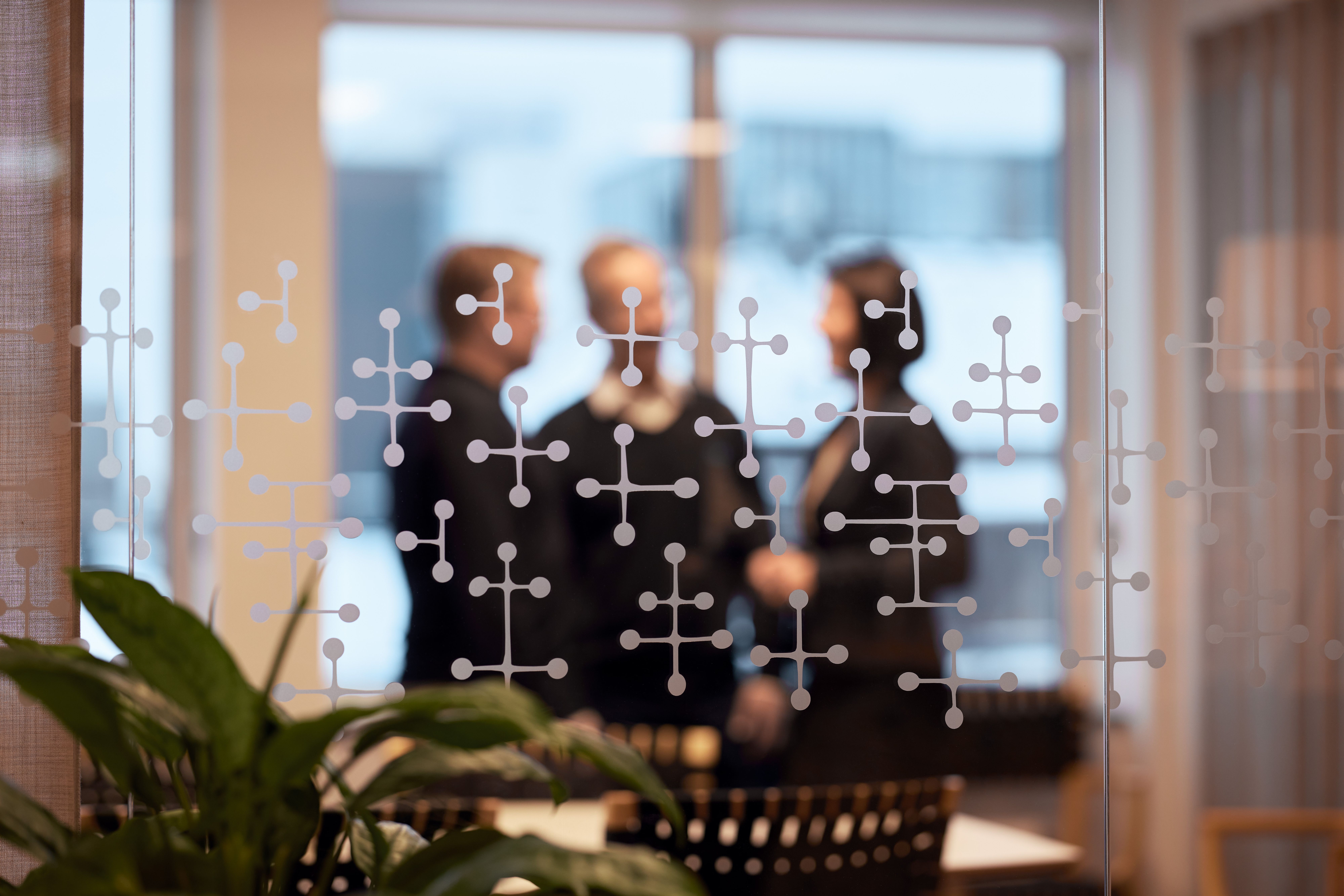 Bild tagen utanför mötesrum på tre personer