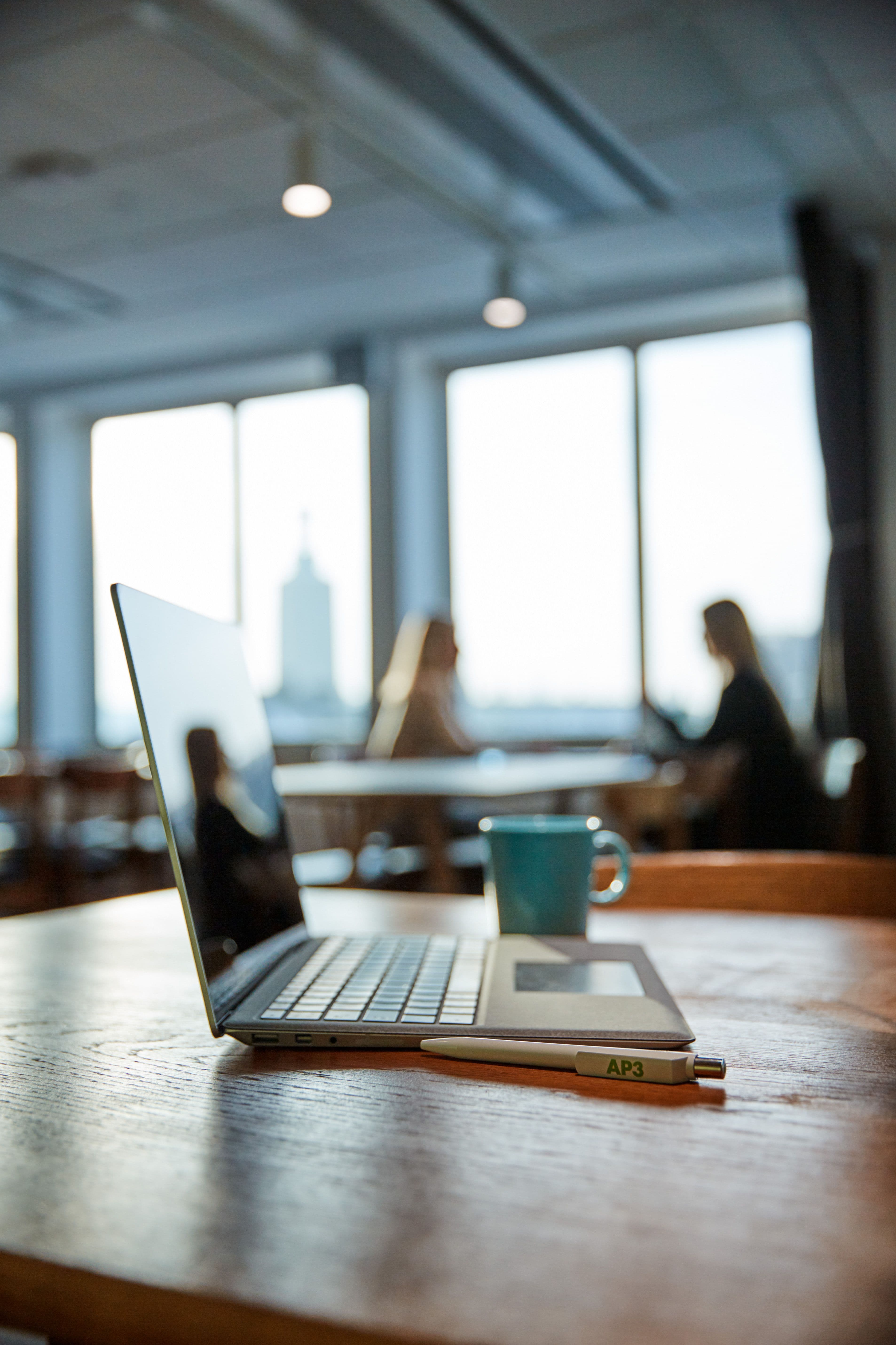 En laptop och en kopp kaffe står på ett bord